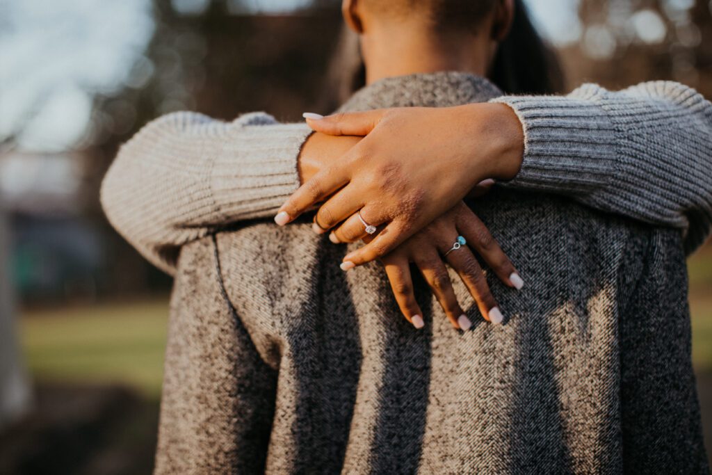 bride's arms around neck showing off ring